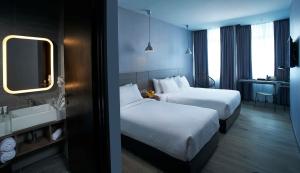 a hotel room with two beds and a sink at Urban H Hotel in George Town