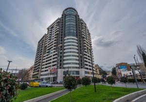 ein hohes Gebäude in einer Stadt mit einem Park davor in der Unterkunft Premium Residence Tbilisi in Tbilisi City