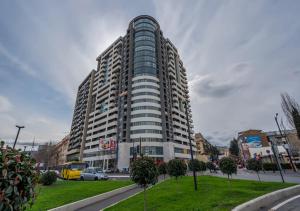 a tall building in a city with a park in front at Premium Residence Tbilisi in Tbilisi City