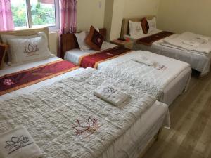 a group of three beds in a room at Kien Thao Hotel in Ha Giang