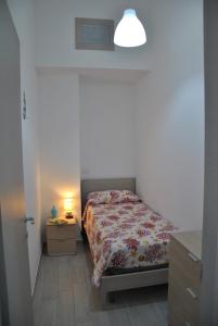 um quarto com uma cama e um candeeiro sobre uma mesa em Fronte mare siculiana marina em Siculiana Marina