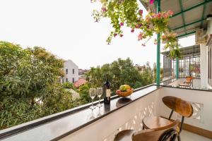 een balkon met een tafel en wijnglazen erop bij Phong Phu Villa Hoi An in Hội An