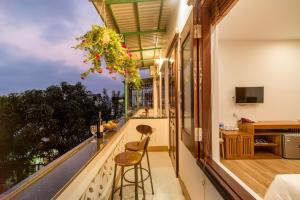 een kamer met een balkon met een bar en krukken bij Phong Phu Villa Hoi An in Hội An