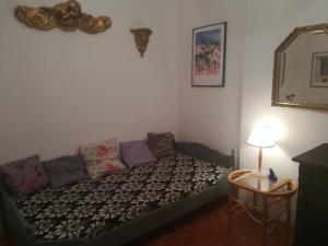 Habitación pequeña con sofá y espejo. en Violetta apartmanlakás, en Hévíz