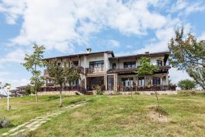 una gran casa en una colina con un patio en Balkana Village en Kalaydzhii