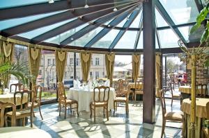 a dining room with tables and chairs in a conservatory at Hotel Maria Helena in Szczawno-Zdrój