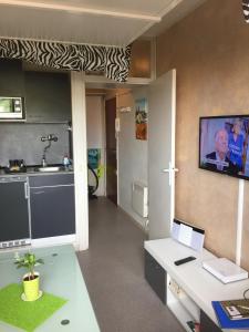 フレジュスにあるFréjus Studioの壁にテレビ付きのキッチンが備わる客室です。