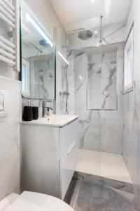 a white bathroom with a shower and a sink at CMG Nation/ Vincennes II in Paris