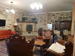 a living room with furniture and a brick wall at Bársonyberek vendégház Bakony in Jásd
