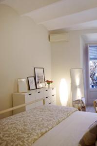 een slaapkamer met een bed, een dressoir en een raam bij Apartament en Plaça Nova , Palafrugell in Palafrugell