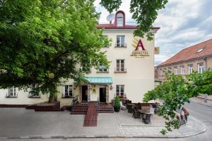 a building with tables and chairs in front of it at Amberton Cozy Hotel Kaunas in Kaunas