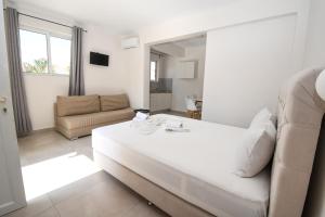 カラマキにあるKalamaki Zakynthos Apartmentsの白いリビングルーム(ソファ、テーブル付)