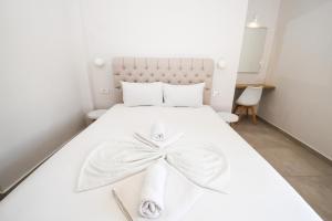 a bedroom with a white bed with a bow on it at Kalamaki Zakynthos Apartments in Kalamaki