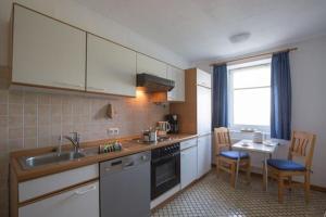 a kitchen with a sink and a table with chairs at Wiesenblick in Pellworm