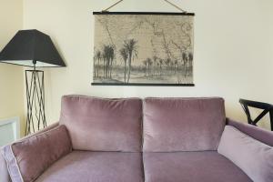 - un canapé dans le salon avec une photo sur le mur dans l'établissement Résidence Grands Boulevards by Studio prestige, à Paris