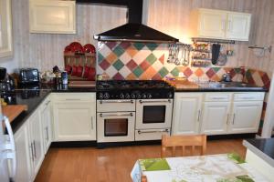 a kitchen with white cabinets and a stove top oven at Maison spacieuse entre la ville et la côte in Saint-Martin-des-Champs