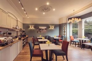 um restaurante com mesas e cadeiras e uma cozinha em Ambleside Townhouse em Ambleside