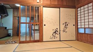 Habitación con puertas de cristal con escritura asiática. en Cottage Yakusugi House, en Yakushima