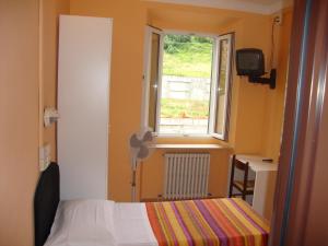 una piccola camera da letto con un letto e una finestra di Albergo Gino ad Ancona