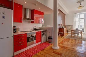 cocina con armarios rojos y alfombra roja en Lisbon Tejo Apartment Best Location with River View, en Lisboa