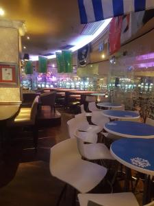 a restaurant with tables and chairs and a bar at Queens Casino and Hotel in Queenstown
