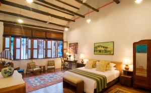 a bedroom with a bed and a table and chairs at 23 Love Lane Hotel in George Town