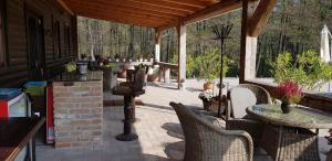 a patio with chairs and a table on a porch at Bársonyberek vendégház Bakony in Jásd