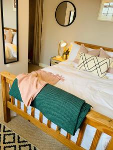 Un dormitorio con una cama con una manta verde. en Weaver's Cottage @ Number 10, en Bradford on Avon