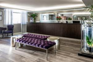 eine lila Bank in einem Wartezimmer mit Salon in der Unterkunft The Hyde All Suite Hotel in Kapstadt