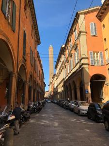 una calle de la ciudad con edificios y una torre alta en Casa Bacìomari, en Bolonia