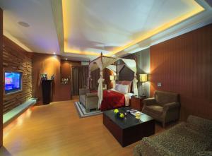 una camera con letto, divano e sedia di Roman Vacation Motel a Dali