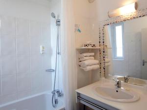 a white bathroom with a sink and a shower at Garrigae Cap Coz in Fouesnant
