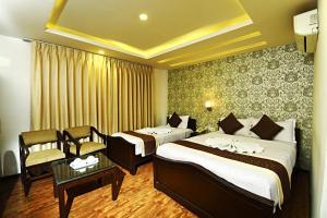 Habitación de hotel con 2 camas y mesa en Kathmandu Grand Hotel, en Katmandú