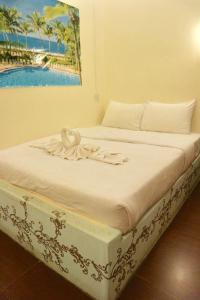 a bed in a room with a painting on the wall at IRIS MOTEL in Tachilek