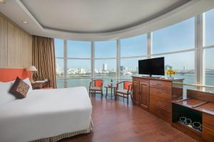 a hotel room with a bed and a television at Sun River Hotel in Da Nang