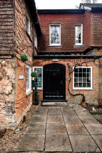 a brick house with a black door on it at Trivelles Waterhall Country Gatwick Hotel & airport parking in Crawley