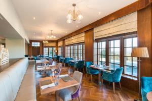a restaurant with tables and chairs and a couch at Murrayshall Country Estate in Perth