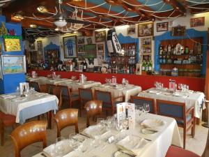 un restaurant avec des tables et des chaises blanches et un bar dans l'établissement Eden Roc I Entreplanta 7, à Marbella