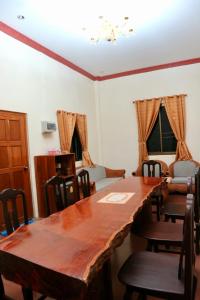 a dining room with a large wooden table and chairs at IRIS MOTEL in Tachilek