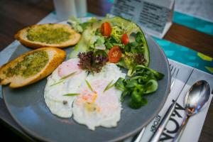 a plate of food with bread and vegetables on a table at Stay inn Hotel Gdańsk in Gdańsk