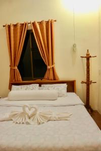 a bedroom with a bed with a heart carved on it at IRIS MOTEL in Tachilek