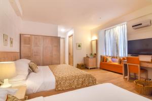 a bedroom with a bed and a television and a couch at The Lynden Grove in Nuwara Eliya
