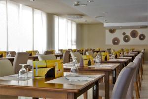 een eetkamer met houten tafels en stoelen bij Hotel Brisa Marina in S'Illot
