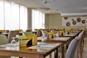 uma sala de jantar com mesas e cadeiras de madeira em Hotel Brisa Marina em S'Illot