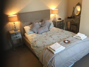 a bedroom with a bed with two lamps and a mirror at Holly Lodge in York