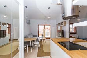 a kitchen and dining room with a table and chairs at Sand - Neptun Park by OneApartments in Gdańsk
