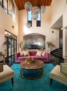康提丁香别墅酒店的客厅里有一张紫色的沙发和一张桌子