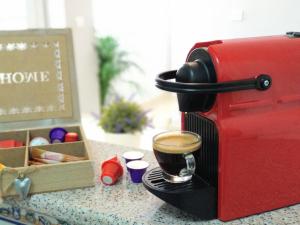 a cup of coffee on a plate next to a red espresso machine at Apartamento Maicandil in Ronda