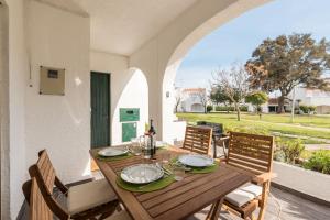 a wooden table and chairs on a patio with a view at LovelyStay - Green Oasis Villa in Vilamoura