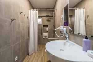 a bathroom with a white sink and a shower at LovelyStay - Green Oasis Villa in Vilamoura